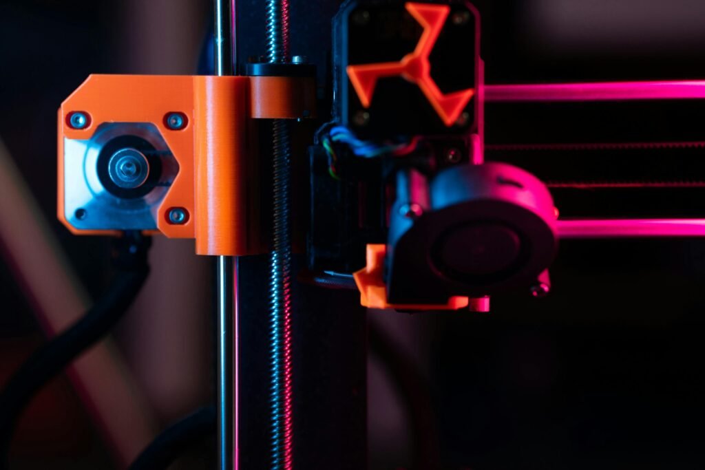 A detailed close-up of a 3D printer showcasing its extruder and components under vibrant lighting.